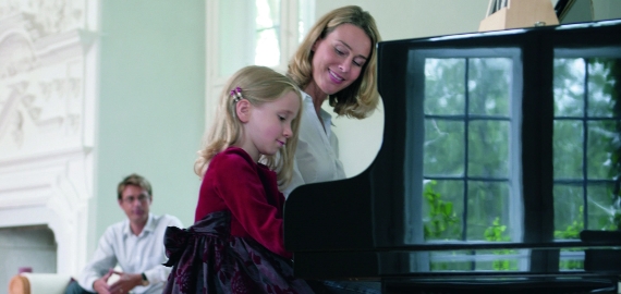 Family playing Schimmel piano
